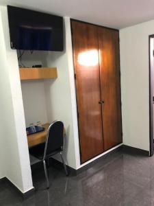 an office with a desk and a wooden door at Oviedo Hotel R in Mérida