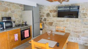 a kitchen with a wooden table with two wine glasses at Casa dos Devezas in São Gregório