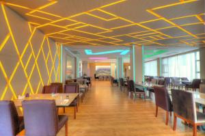 a dining room with tables and chairs and yellow ceilings at One One Bangkok in Bangkok