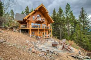 a log cabin in the woods with a fire pit at Sagle Sunrise in Sagle