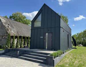 a black house with a black roof at Stodoła Parysa in Wola Korytnicka
