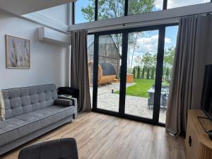 a living room with a couch and a sliding glass door at Stodoła Parysa in Wola Korytnicka