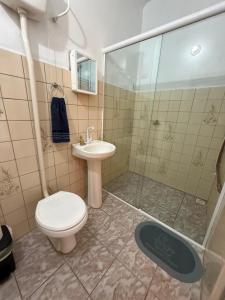 a bathroom with a toilet and a sink and a shower at Kitnets Kretzer Hinckel 3 - CENTRO in Alfredo Wagner +7 photos