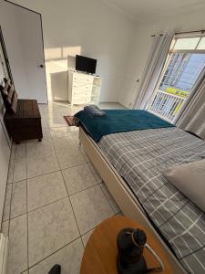 a bedroom with a bed and a table and a window at Kitnets Kretzer Hinckel 3 - CENTRO in Alfredo Wagner