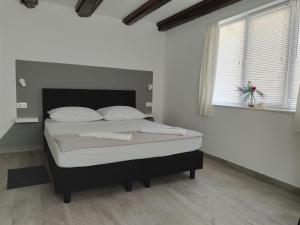 a bedroom with a large bed in a room with a window at Studios Ciao Bella city centre with free parking in Šibenik