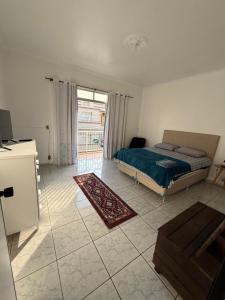 a bedroom with a bed and a large window at Kitnets Kretzer Hinckel 3 - CENTRO in Alfredo Wagner