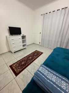 a bedroom with a bed and a dresser with a television at Kitnets Kretzer Hinckel 3 - CENTRO in Alfredo Wagner