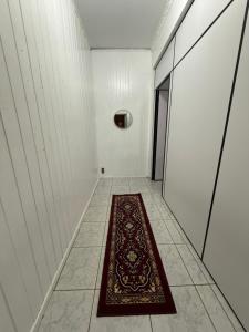 a hallway with a red rug on a tile floor at Kitnets Kretzer Hinckel 3 - CENTRO in Alfredo Wagner