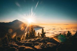 a view of a mountain with the sun rising over the clouds at Blue Gold Escape - Ocean view, airco, heated pool in Adeje +41 photos