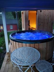 a hot tub on a wooden deck with a table at Solhaug in Torpo