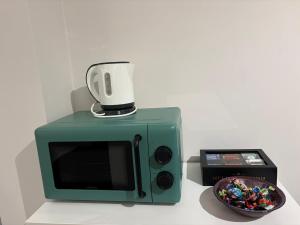 a green microwave sitting next to a bowl of candy at Dimora in Prato in Padova