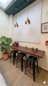 a dining room with a table and four stools at La Toscana Hostel in Villa de Leyva