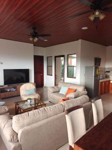 a living room with couches and a ceiling fan at Altura & lago in San Nicolás