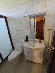 a white bathroom with a toilet and a sink at Altura & lago in San Nicolás +9 photos