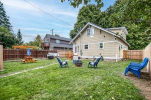 a yard with blue chairs in front of a house at South Sandpoint Charmer in Sandpoint