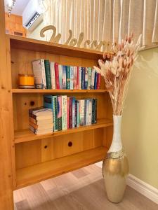 a vase with flowers in front of a book shelf at Private Guest Suit-Self Checkin-Near Downtown in Charlottetown