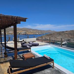 a swimming pool with chaise lounge chairs next to a resort at Utopia Kythnos Althea in Kithnos