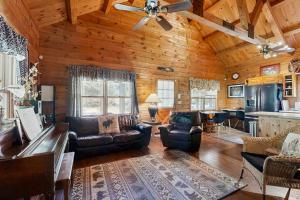 a living room with leather furniture in a log cabin at Easton Escape a notch above in Sugar Hill