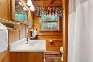 a bathroom with a sink and a toilet and a window at Easton Escape a notch above in Sugar Hill +43 photos