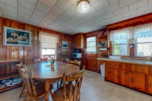 a dining room with a wooden table and a kitchen at Beach Bungalow in Seabrook