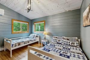 two beds in a room with blue walls and wooden floors at The Lodge in Madison