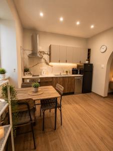 a kitchen and dining room with a table and chairs at Sliema Arch Suites Modern Boutique Apartment in St. Julianʼs