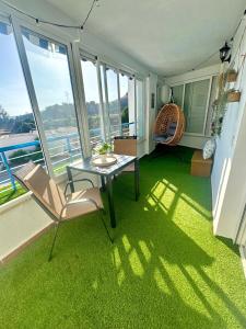 a room with a table and chairs on a balcony at Oasis de Málaga in Chilches