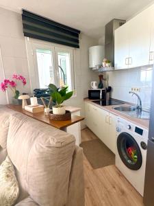 a kitchen with a washing machine and a sink at Oasis de Málaga in Chilches