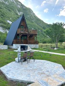 a log cabin with a deck and a table and chairs at Komarnica Forest Owl 2 in Šavnik