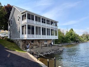 a large house on the side of a river at North Hero House Inn and Resort in North Hero