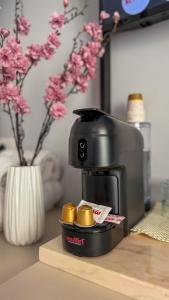 a coffee maker sitting on a table with gold coins at TreA Suites By Aria in Vlorë