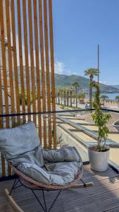 a wicker chair sitting on top of a deck at TreA Suites By Aria in Vlorë