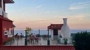 a deck with a table and chairs and a fireplace at Anthoussa Rooms in Parga