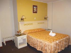 Un dormitorio con una cama con un cisne. en Hotel San Martín, en Tacna