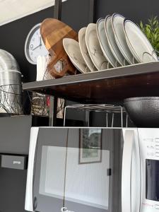 a plate rack with plates on it next to a microwave at Studio apartman Gradna in Samobor +24 photos