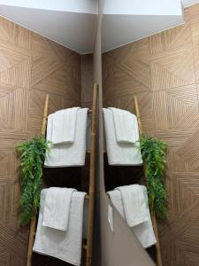 a towel rack with white towels and plants at Alojamientos LUMARA in Peal de Becerro