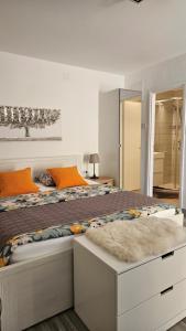 a bedroom with a large bed with orange pillows at Apartments No 55 in Baška