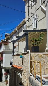 a building with a stone wall next to a house at Apartments No 55 in Baška