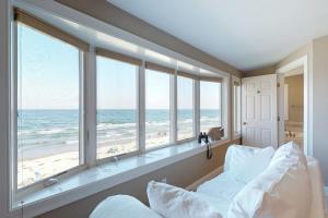 a bedroom with a bed and a view of the beach at Shang-Rye-La in Rye