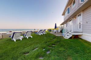 a group of chairs sitting on a lawn next to a house at Shang-Rye-La in Rye