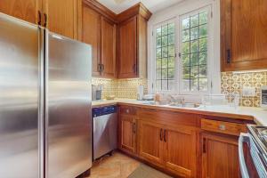 a kitchen with wooden cabinets and a stainless steel refrigerator at Point Radio Cottage in Gloucester