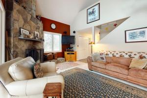 a living room with a couch and a stone fireplace at The Ski Haus in Jackson