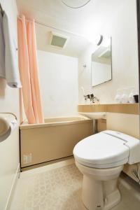 a bathroom with a toilet and a sink and a tub at Select Inn Yaizu Ekimae in Yaizu