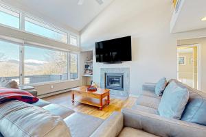 a living room with a couch and a fireplace at Tin Mountain Treetops Time in Jackson