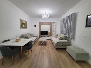 a living room with a couch and a table at Vila Mollanji in Tirana +6 photos