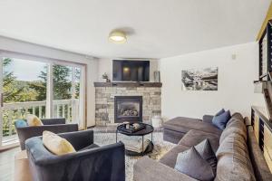 a living room with a couch and a fireplace at Apres Escape in Sandpoint