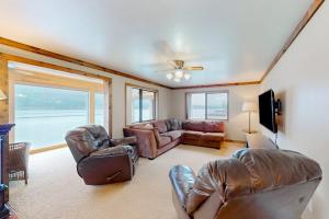 a living room with leather furniture and a large window at On the Shoreline in Cocolalla