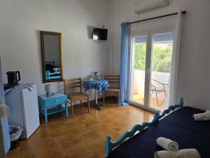 a bedroom with a bed and a table and chairs at Tony's Rooms in Alinda