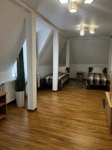 a large room with two beds and a wooden floor at Готель Сузірʼя in Kolomiya