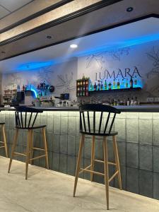 a bar with two chairs in front of a counter at Alojamientos LUMARA in Peal de Becerro